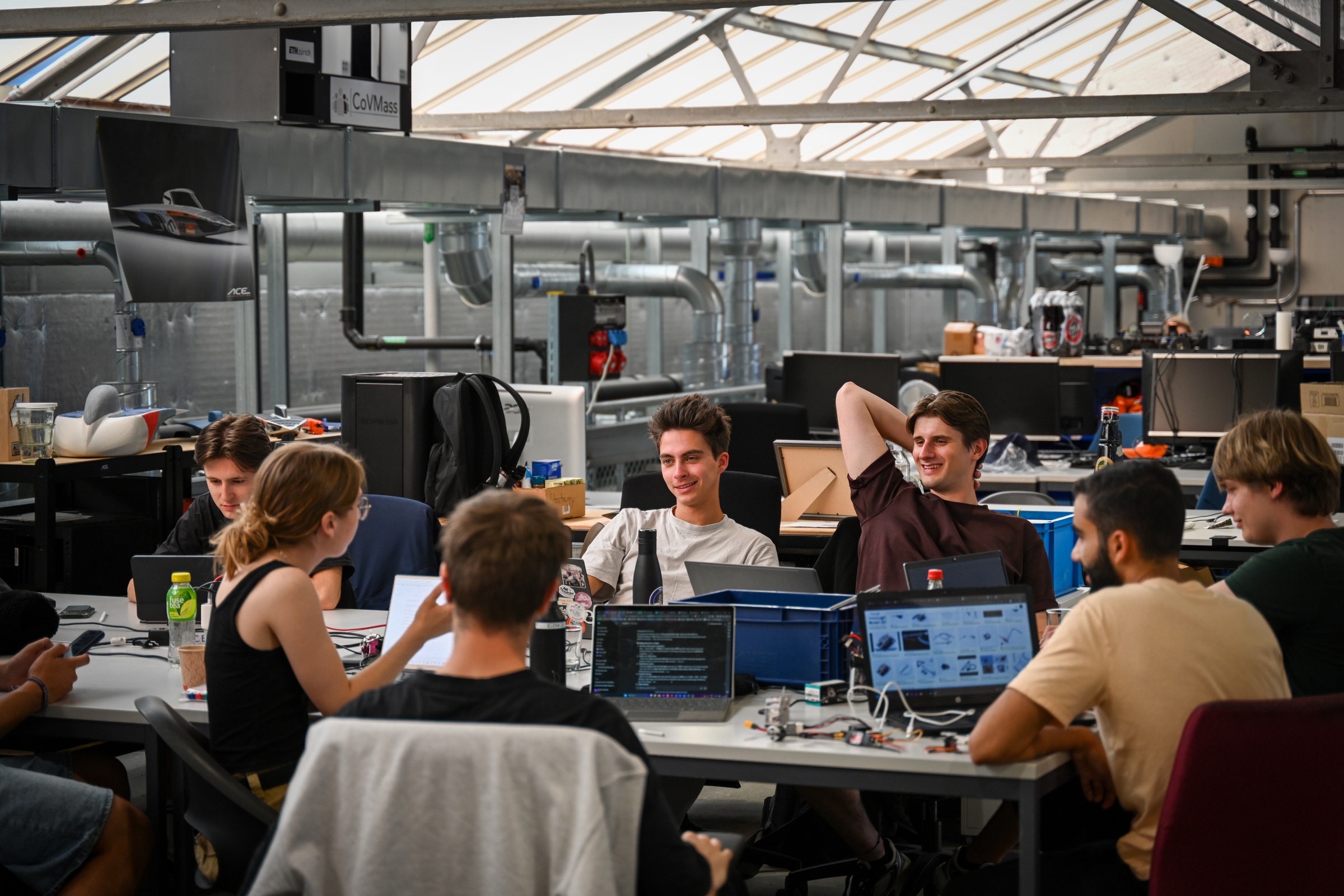Zephyr team gathered around laptops in their shared workspace